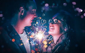 Влюбленные парень и девушка с бенгальским огнем в руке