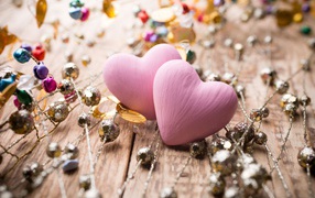 Два розовых сердца на деревянном фоне с элементами декора