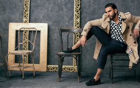 Индийский актер Ранвир Сингх сидит на стуле