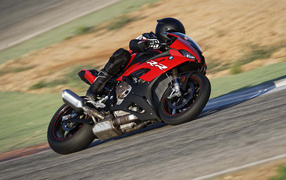 Гонщик на мотоцикле BMW S1000 совершает крутой поворот
