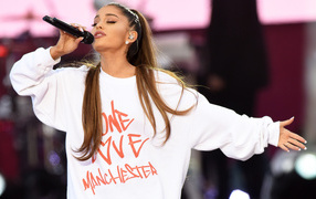 Молодая девушка, певица Ариана Гранде поет на сцене