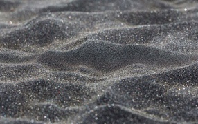 Блестящий черный песок крупным планом