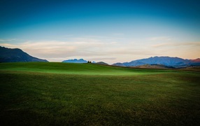 Зеленый луг на фоне красивого неба