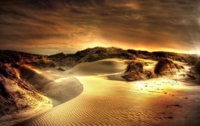 Волнистый песок под красивым небом на закате