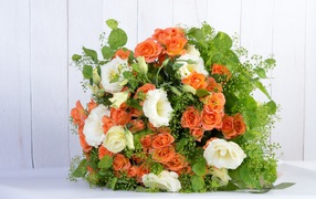 A large beautiful festive bouquet of orange roses and flowers of eustoma