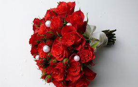 Красивый букет красных роз с жемчужными бусинами на сером фоне