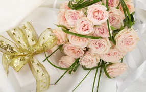 Bouquet of pink roses and a gift with a beautiful bow