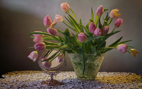 Розовые тюльпаны в стеклянной вазе на столе с зеркалом 