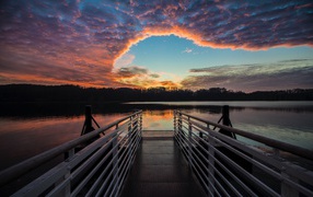 Мост на озере на фоне красивого неба на закате