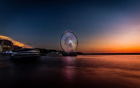 Ferris wheel by the water at sunset