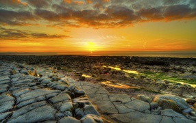 Каменный берег на фоне красивого неба на закате солнца