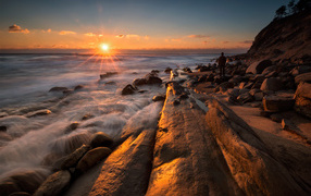 Каменный берег на морском побережье на закате солнца