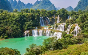 Водопад стекает с гор на фоне зеленой природы