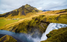 Водопад на фоне покрытых зеленью гор, Исландия