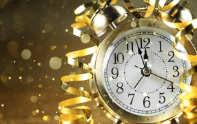 Стрелки новогоднего будильника с серпантином доходят до двенадцати ночи