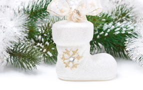 Ботинок с бантом и зеленая еловая ветка на белом фоне на Новый год 