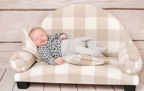 Грудной ребенок спит на диване