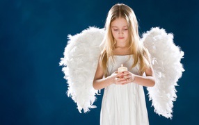 Девочка с белыми крыльями ангела со свечой в руках