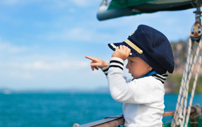 Маленький мальчик в форме капитана на корабле