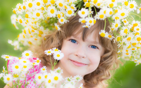 A little girl with a wreath of daisies on her head