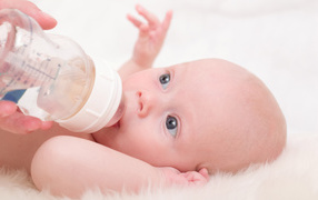 Новорожденного ребенка кормят с бутылки