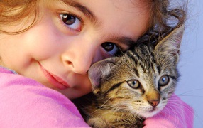 Маленькая кареглазая девочка с серым котом