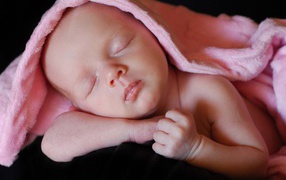 Милый спящий младенец под розовым покрывалом