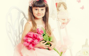 Красивая милая голубоглазая девочка с букетом розовых тюльпанов