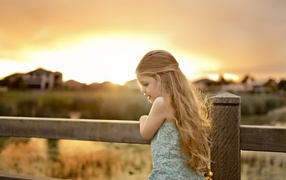 Красивая маленькая девочка на закате солнца