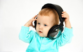 Blue-eyed boy in big headphones on a white background