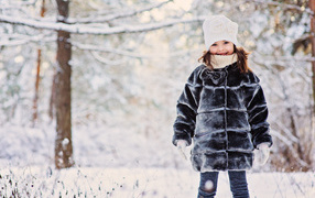 Милая маленькая девочка в шубе зимой