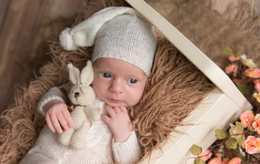 Little baby in knitted suit with a bunny