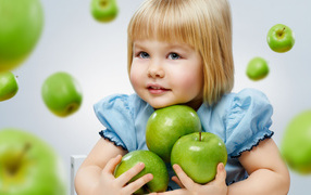 Маленькая девочка блондинка с зелеными яблоками