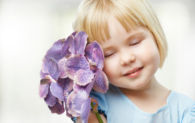 Little blonde girl with orchid flowers