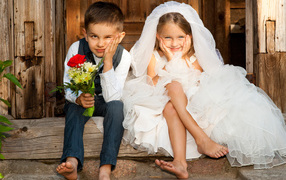 Маленькие мальчик и девочка в нарядах жениха и невесты