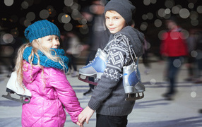 Маленькие мальчик и девочка на катке