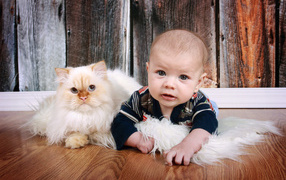 Little boy lying on the floor with a cat
