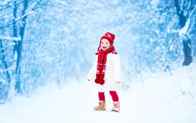 Маленькая веселая девочка в зимнем лесу