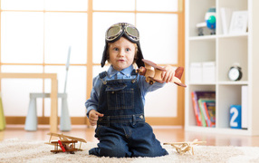 Маленький будущий летчик играет с самолетом