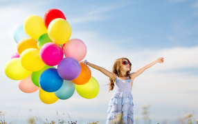 Little girl holding many balloons in her hand