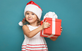 Маленькая девочка в новогоднем костюме с подарком на голубом фоне