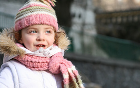 Маленькая девочка в теплой шапке с шарфом