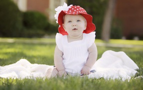 Маленькая девочка в белом платье и красной шляпе