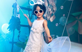 Little girl in a white dress and black glasses