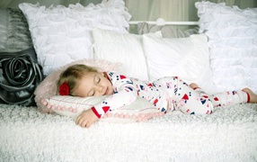 Маленькая девочка спит на подушке