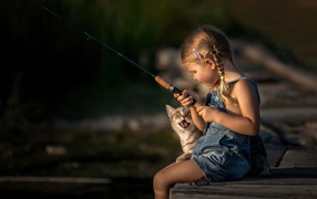 Little girl on a fishing trip with a cat