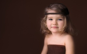 Little girl with a bandage on her head photo on a brown background