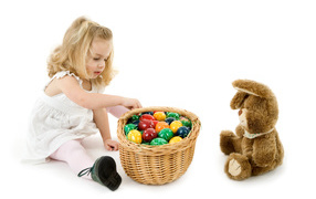Маленькая девочка с корзиной пасхальных яиц и игрушкой на белом фоне