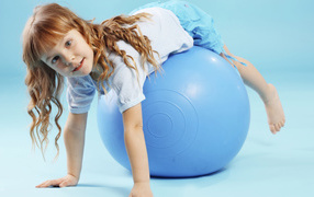 Маленькая девочка с большим голубым мячом