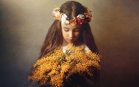 Little girl with a bouquet of mimosa in hands